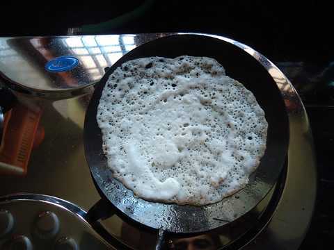 Representative photograph of Appam Hoppers. The photograph shows a Kerala appam cooking in a pan; this draft follows a Sri Lankan-style hopper batter.