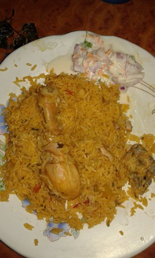A representative Ambur chicken biryani with accompaniments. Portions and side dishes vary.