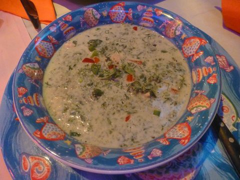 Representative photograph of Callaloo with Coconut. The photograph shows a soupier callaloo preparation; this draft reduces the coconut liquid around chopped greens.