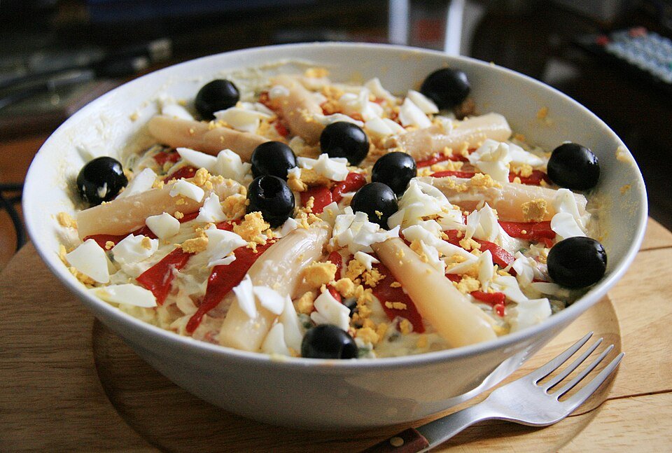 Representative photograph of Ensaladilla Rusa. The photograph includes olives and pepper garnish.