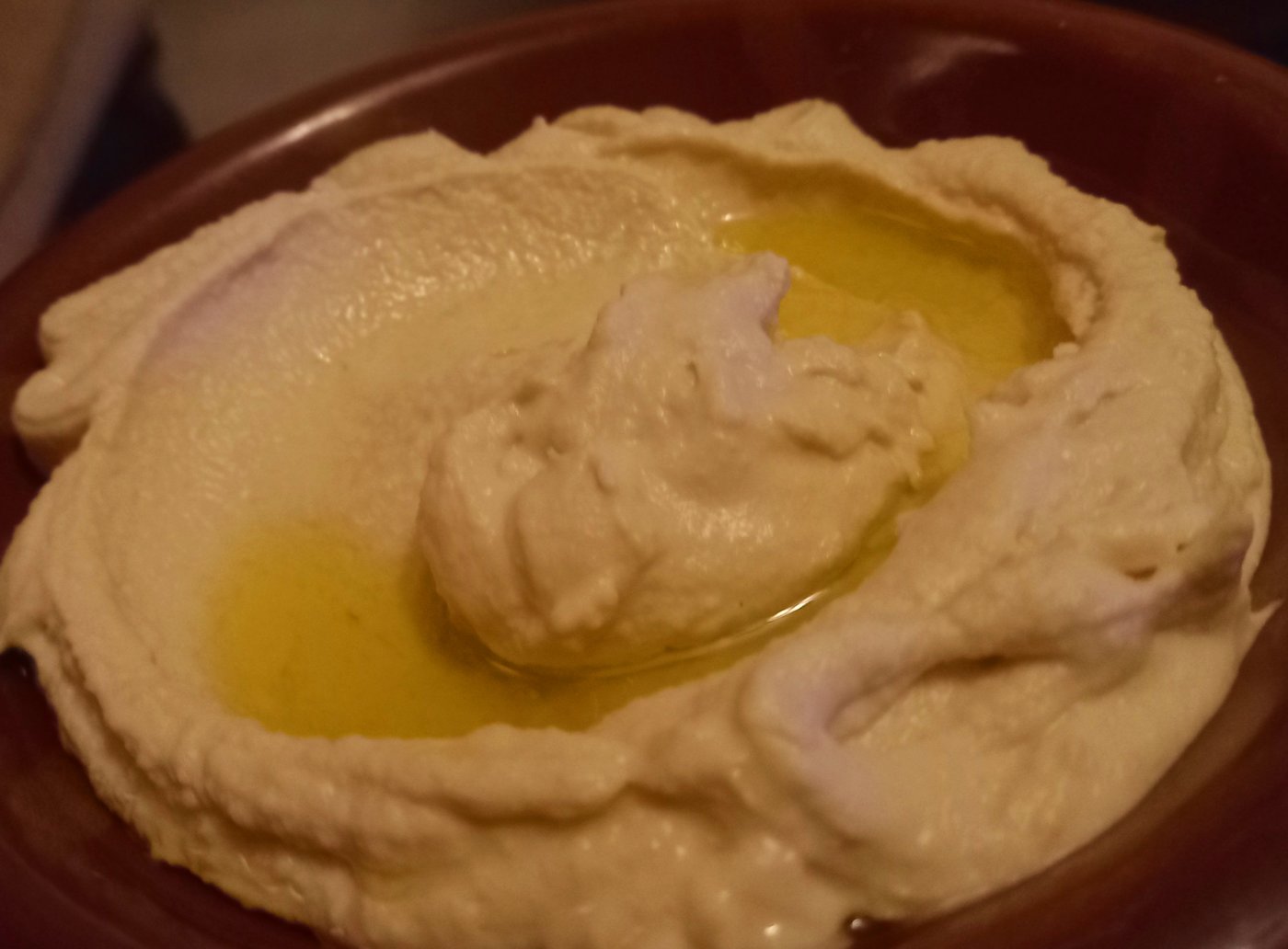 Hummus with olive oil in a shallow bowl