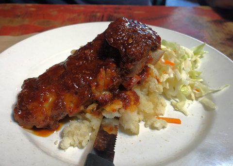 Representative photograph of Jamaican Jerk Chicken. The photograph includes rice and slaw not included in this draft.