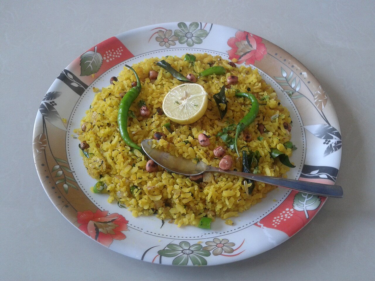 Yellow poha with peanuts, curry leaves, whole green chilies and lemon