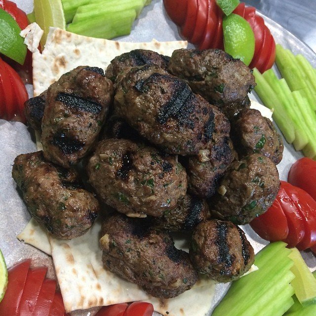 Representative photograph of Lamb Kofta. The photo shows grilled patties; shape the mixture as directed in this recipe.