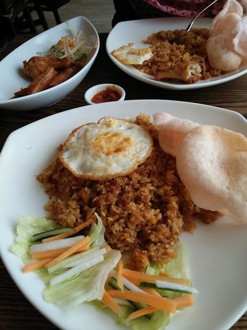 Representative photograph of Nasi Goreng. The photograph includes crackers and salad accompaniments not included in this draft.